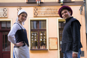 People in traditional costumes by brick oven